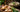 Fresh sliced galangal with lemongrass, kaffir lime leaves and a bowl of tom kha soup