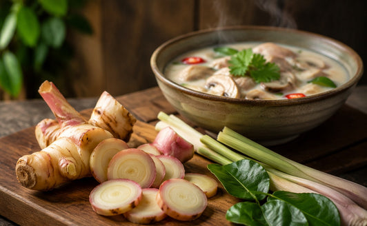 Fresh sliced galangal with lemongrass, kaffir lime leaves and a bowl of tom kha soup