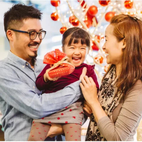 Happy family celebrating Christmas in China with decorations and gifts 🎁, embodying Christmas traditions in China.
