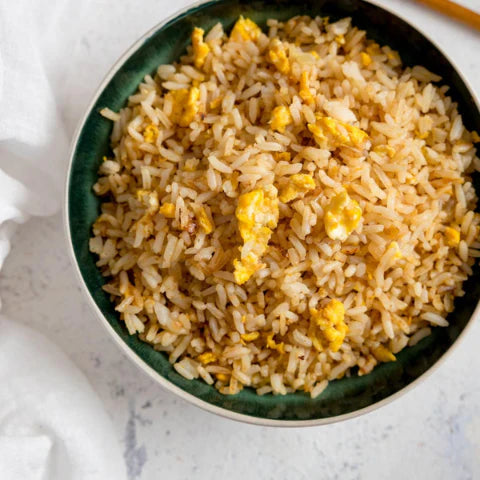 Delicious bowl of 🍚 perfect egg fried rice recipe topped with chunks of 🍳 golden egg, ready to enjoy.