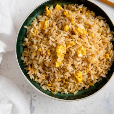 Delicious bowl of 🍚 perfect egg fried rice recipe topped with chunks of 🍳 golden egg, ready to enjoy.